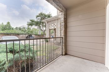 A balcony with a metal railing and a stone pillar.